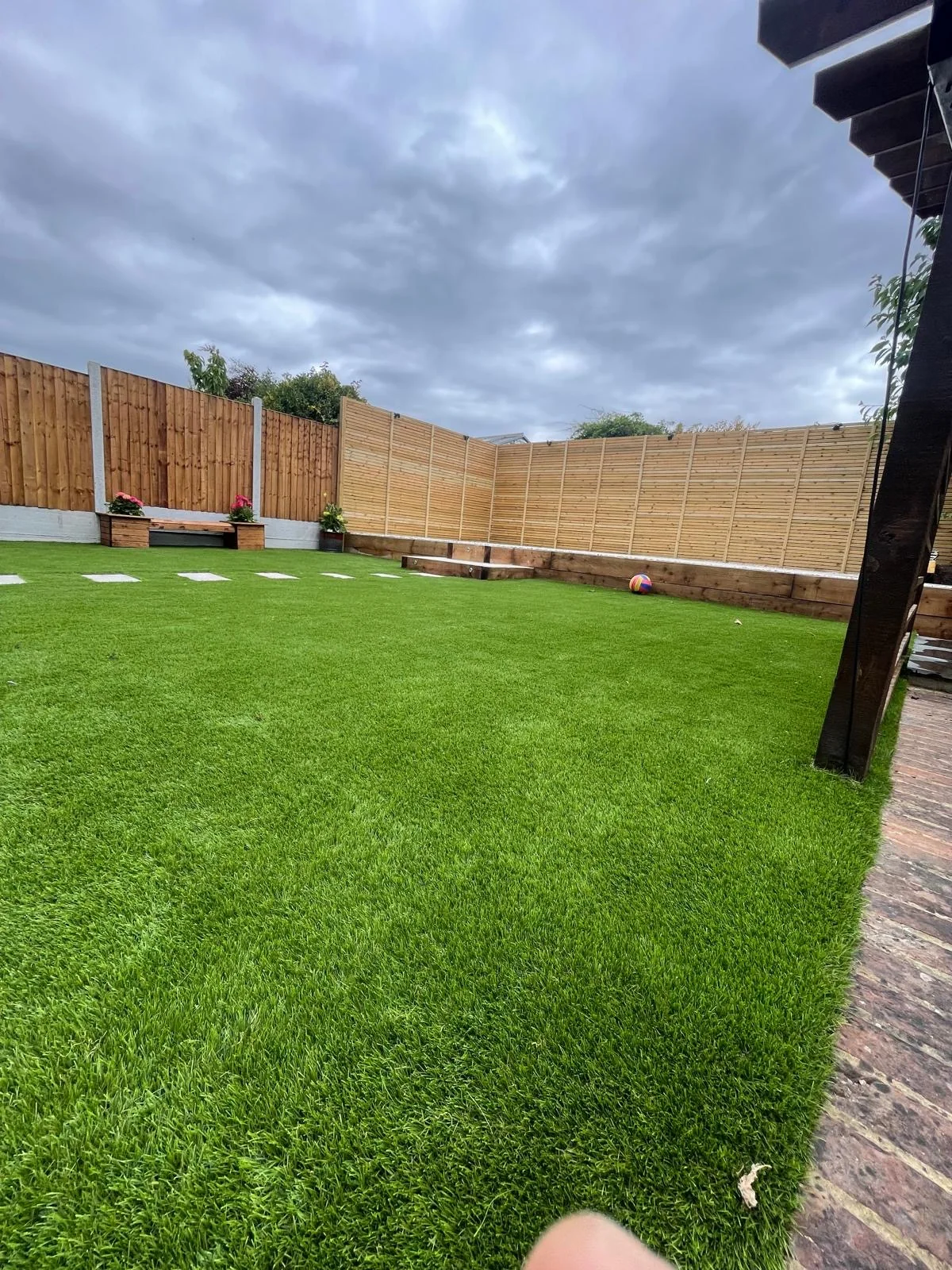 Large artificial lawn with boundary fencing