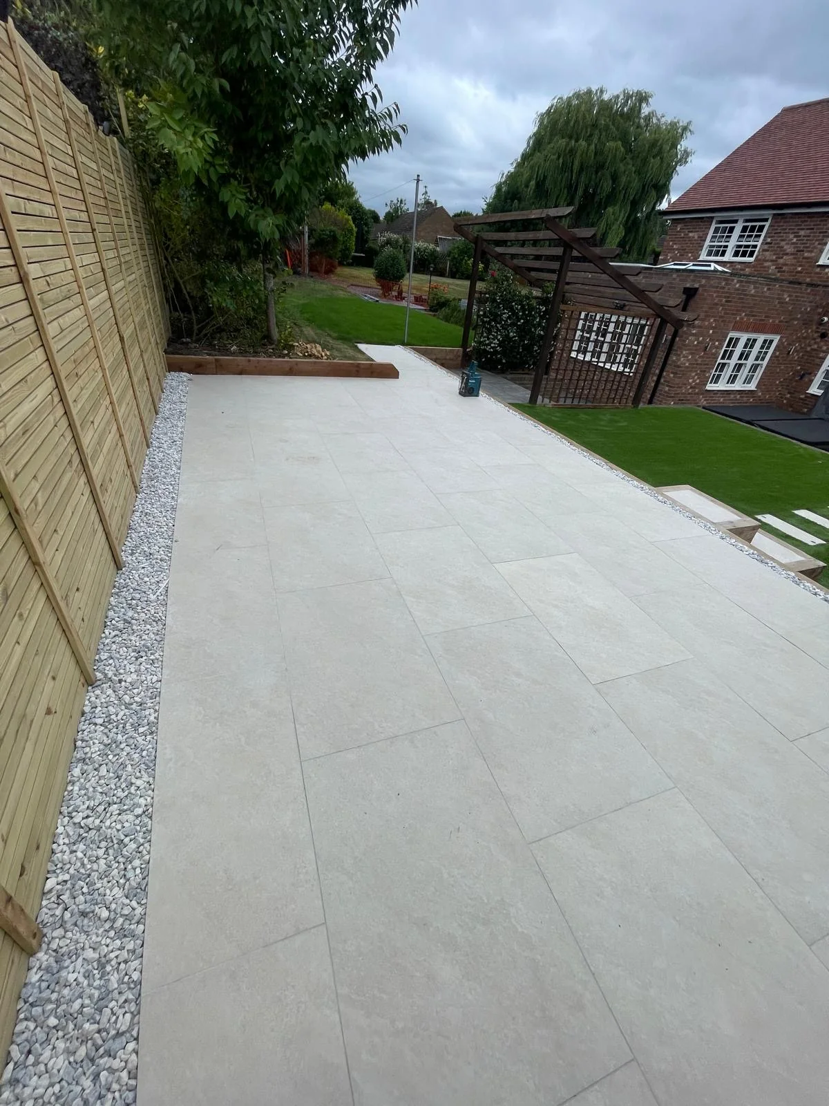 Paved garden terrace with pergola and lawn