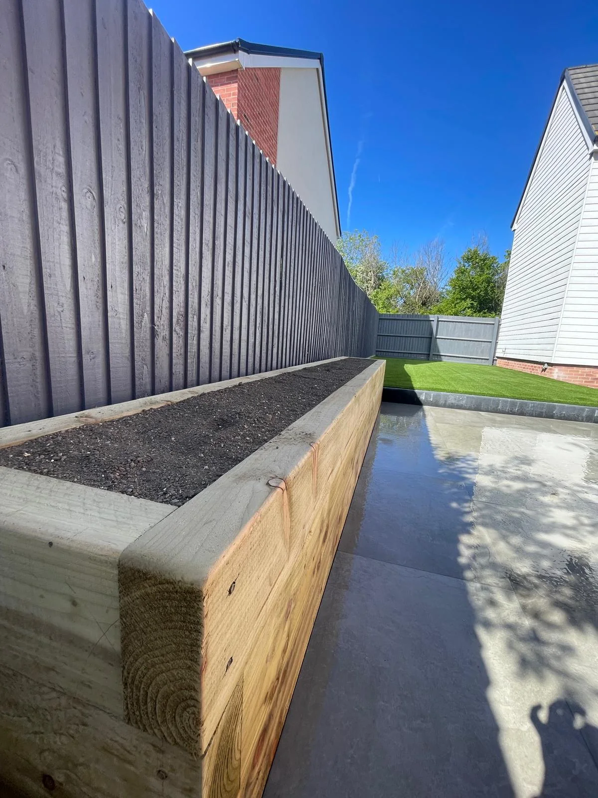 Landscaped side garden with boundary fencing and timber feature