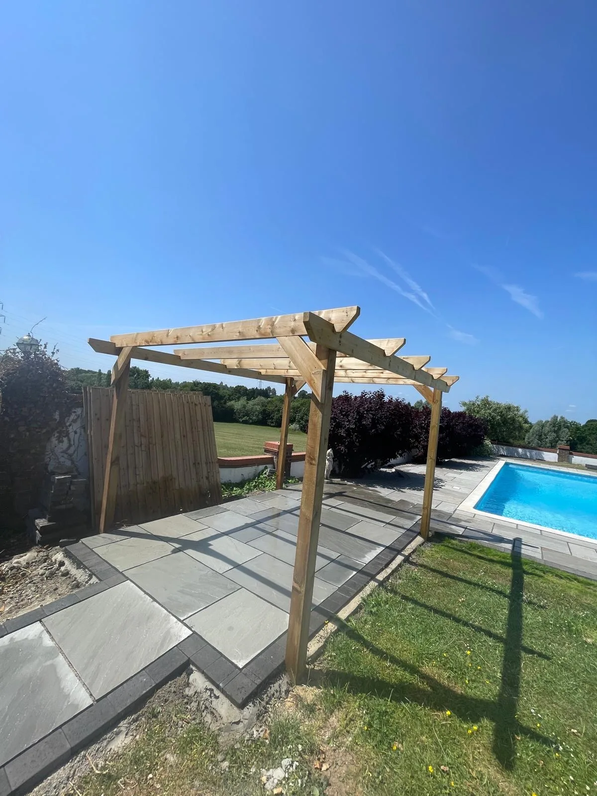 Timber garden structure beside paved outdoor area